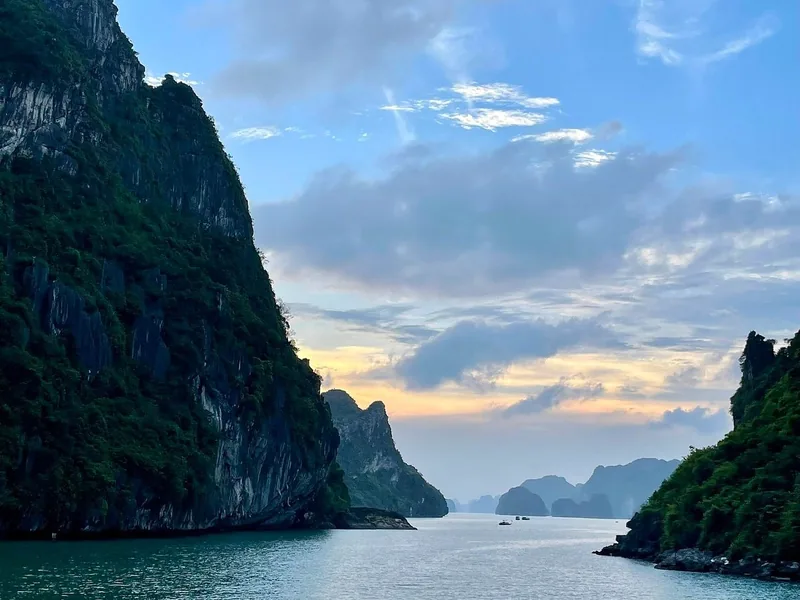Limestone karsts frame a calm channel at sunset in Lan Ha Bay near Cat Ba