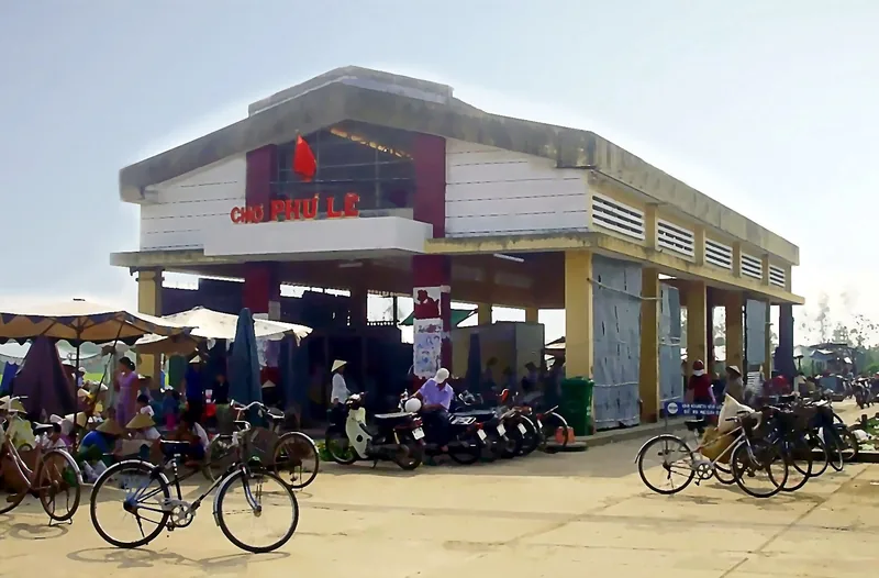 Bicycles and motorbikes are parked outside the Cho Phu Le market building in the Mekong Delta.